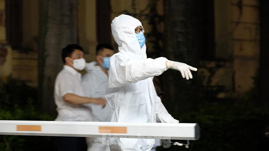 Nhân viên y tế khử khuẩn ở trụ sở Bộ Giao thông Vận tải vào tối nay. Ảnh: Hoàng Mạnh Thắng.