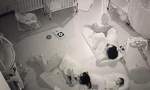 Cô giáo nằm đè dỗ ngủ xong quay sang đùa với bé khác. (Ảnh chụp từ clip)