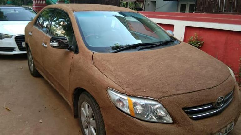 Người phụ nữ Ấn Độ dùng phân bò phủ lên ôtô để chống nóng