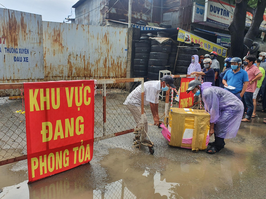 Người dân nhận hàng từ bãi xe bị phong tỏa.