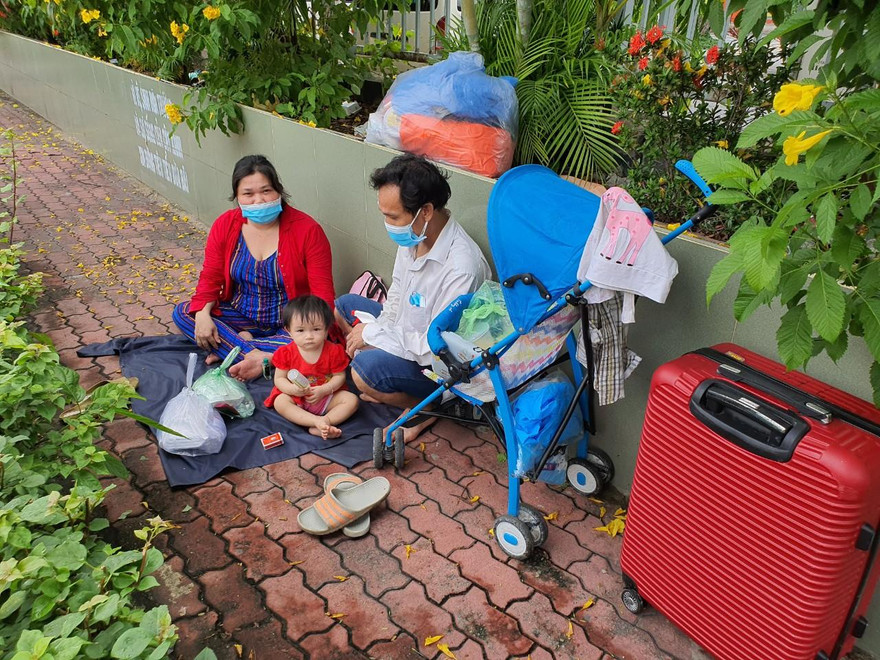 Gia đình chị Thu ngồi chờ xe của Hội đồng hương đón về quê