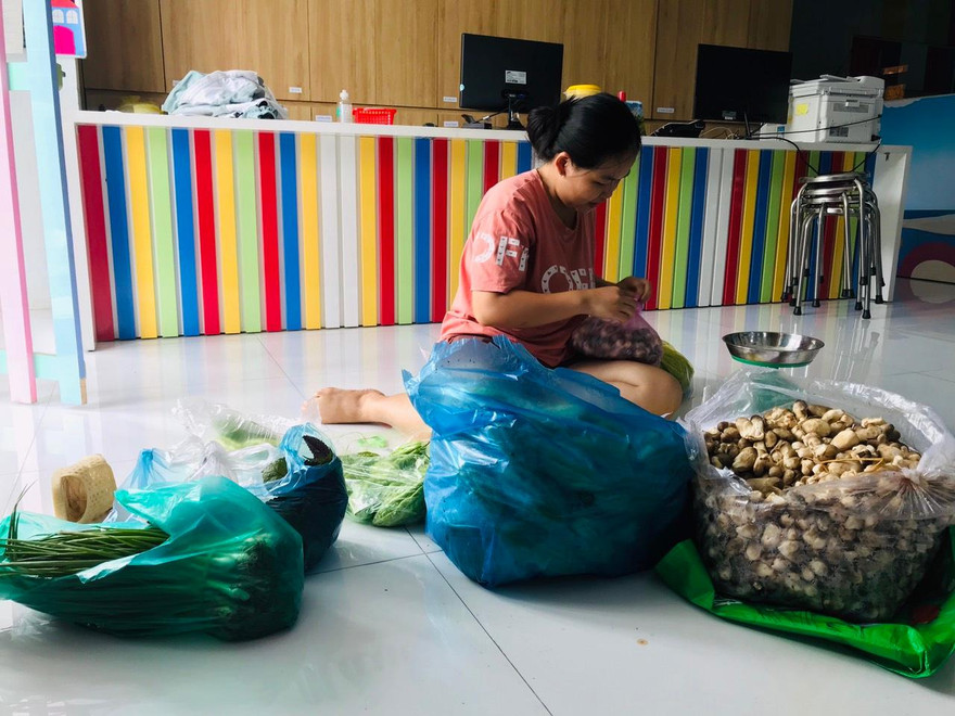 Một bảo mẫu của Trường mầm non Nhân văn, quận 12 chuẩn bị rau, củ, quả để giao cho khách