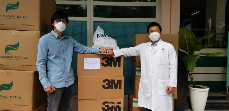Đại diện Báo Tiền Phong tại TPHCM (trái) tặng đồ bảo hộ khẩu trang cho Bệnh viện Nhân Dân 115