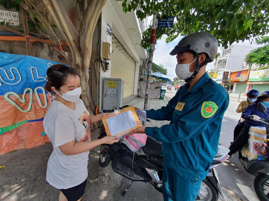 Anh dân quân tự vệ giao SGK cho phụ huynh ở quận Gò Vấp