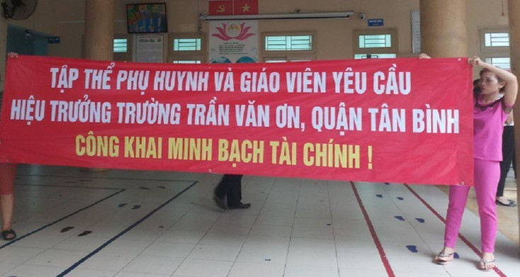Phụ huynh căng băng rôn phản đối hiệu trưởng trường Trần Văn Ơn (N.S)