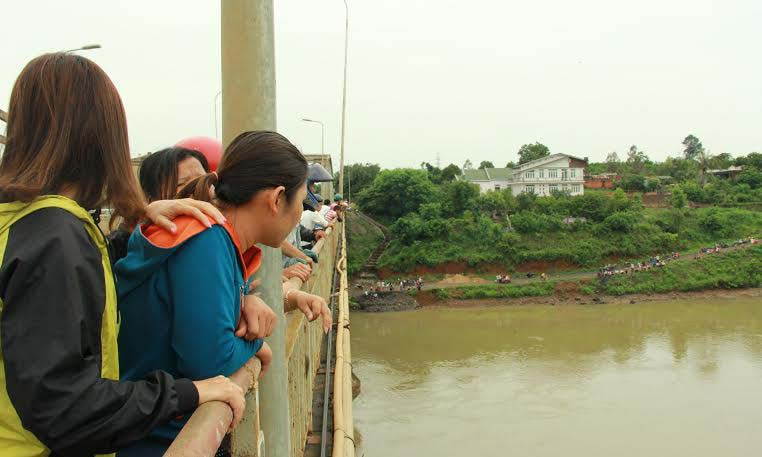 Nhiều người hiếu kỳ theo dõi cơ quan chức năng tìm kiếm thi thể nam thanh niên nhảy cầu tự tử. 