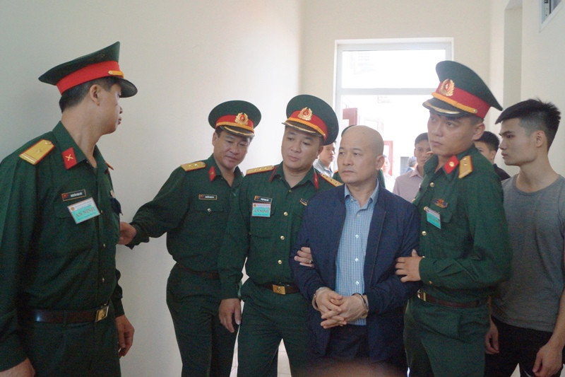 Dẫn giải bị cáo Đinh Ngọc Hệ ra khỏi phòng xử án sau phiên xét xử sáng nay. Ảnh: Nguyễn Minh