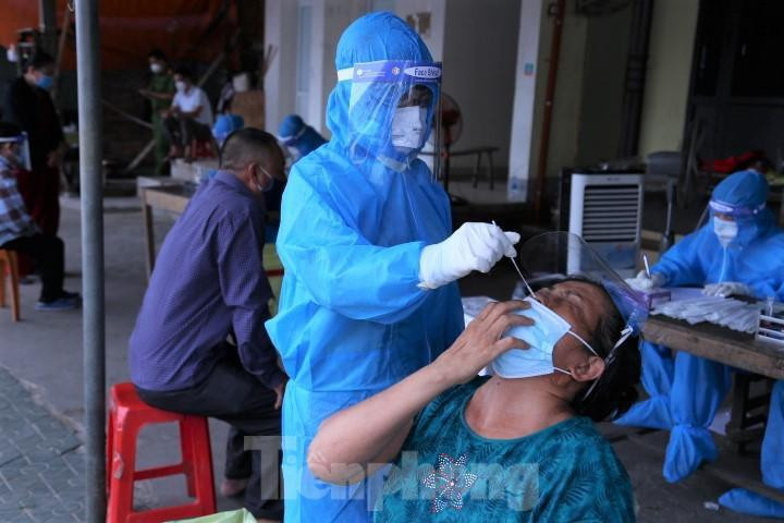 Lấy mẫu xét nghiệm cho tiểu thương ở chợ đầu mối Vinh.