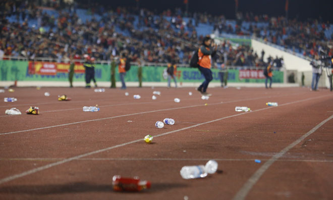 CĐV bày tỏ sự thất vọng bằng những chai nước ném xuống sân. Ảnh: Như Ý