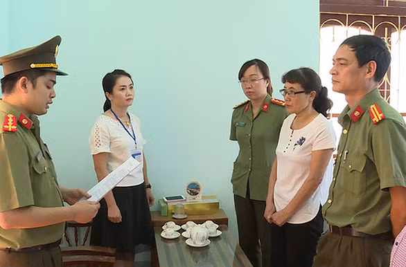 Cơ quan điều tra đọc lệnh khởi tố bị can Nguyễn Thị Hồng Nga (áo trắng, đeo kính).