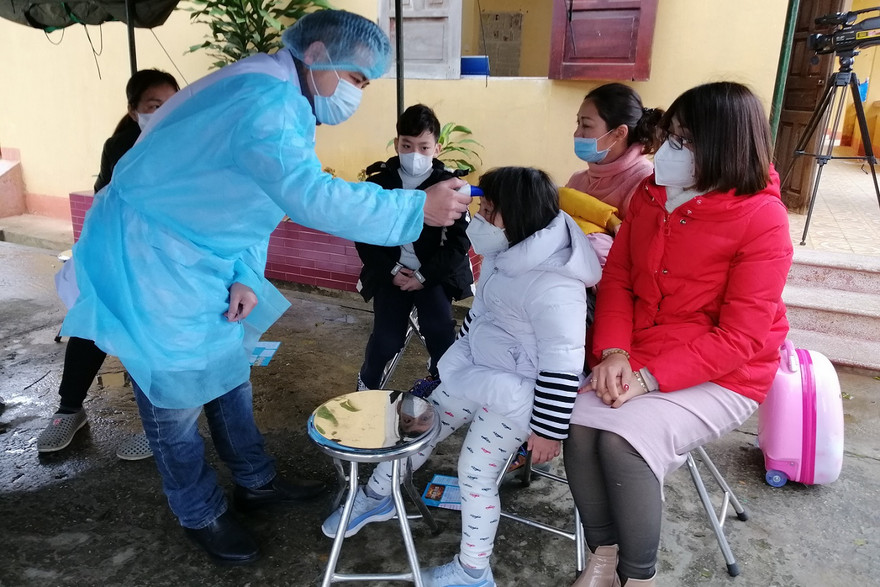 Cán bộ y tế Lạng Sơn kiểm tra sức khỏe ban đầu đối với công dân Việt Nam trở về từ Trung Quốc trước khi chuyển đến khu tiếp nhận, cách ly tại Trung đoàn 123 (Bộ CHQS tỉnh Lạng Sơn). Ảnh: Bùi Hiệp