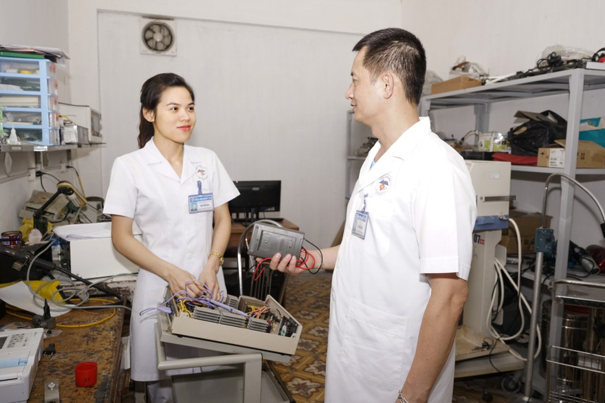 Đại úy Bùi Thị Hoa (bên trái) trao đổi công việc cùng đồng nghiệp 