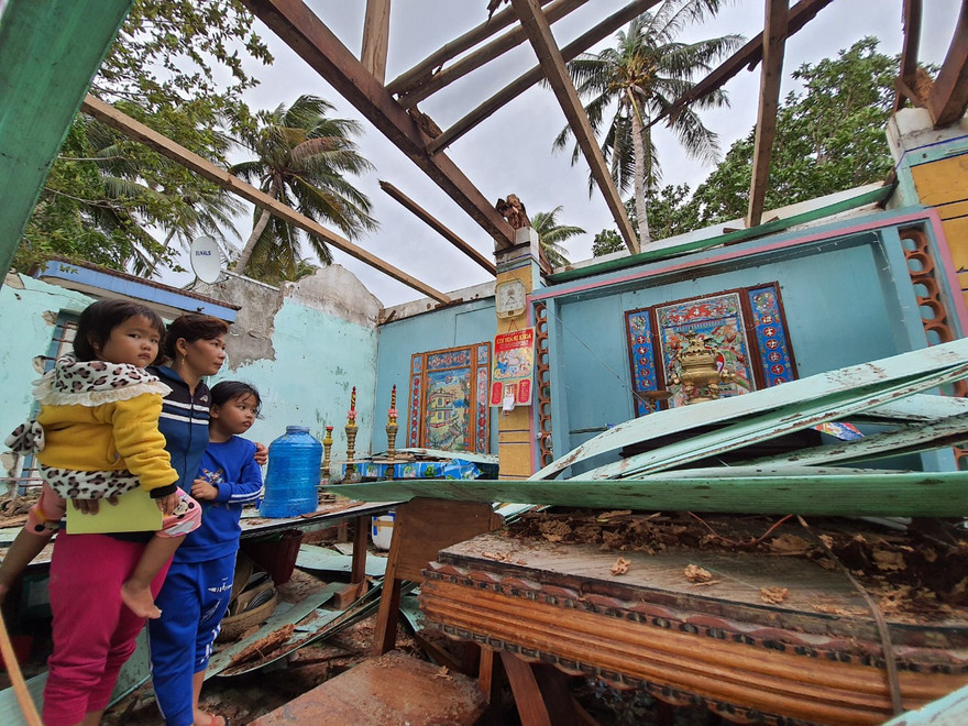 Chị Nguyễn Thị Sương Mai (trú thôn Hòa Lợi, Thị xã Sông Cầu) đứng ôm hai con nhỏ bên căn nhà bị tốc mái, đổ nát do bão...