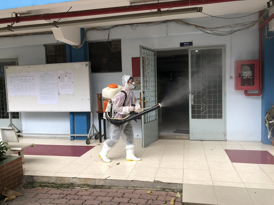 Nhân viên khử khuẩn trường lớp tại điểm thi THPT Nguyễn Du, quận 10 chuẩn bị cho kỳ thi tốt nghiệp THPT