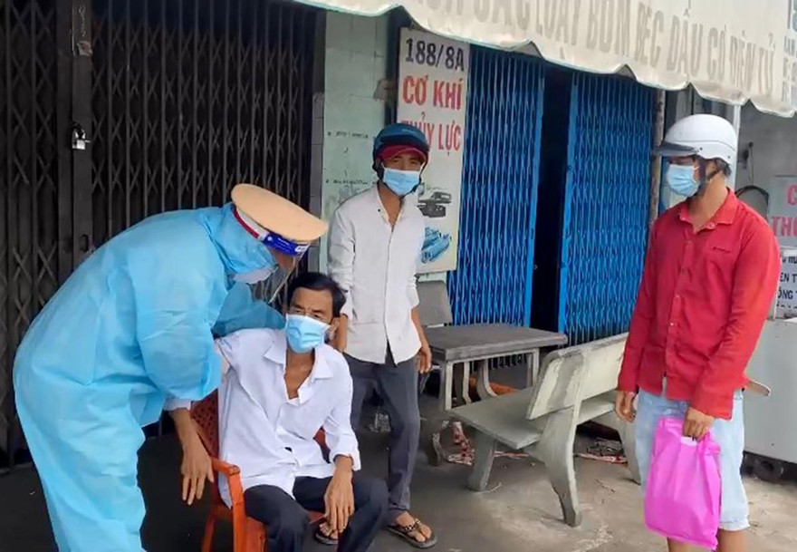 Cán bộ CSGT Tân Túc đỡ ông G. lên xe đặc chủng.