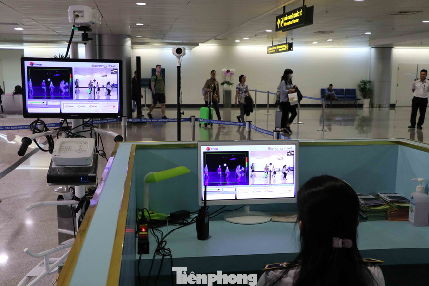 Nhân viên y tế theo dõi thân nhiệt khách quốc tế nhập cảnh vào sân bay Tân Sơn Nhất.