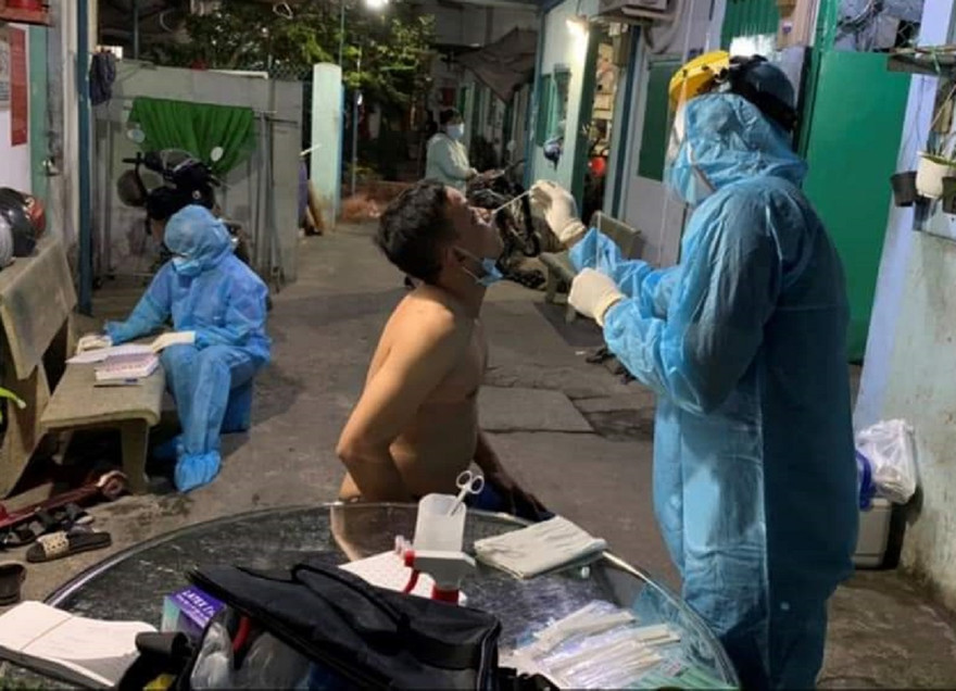 Nhân viên y tế lấy mẫu xét nghiệm những người trong khu dân cư bị cách ly.