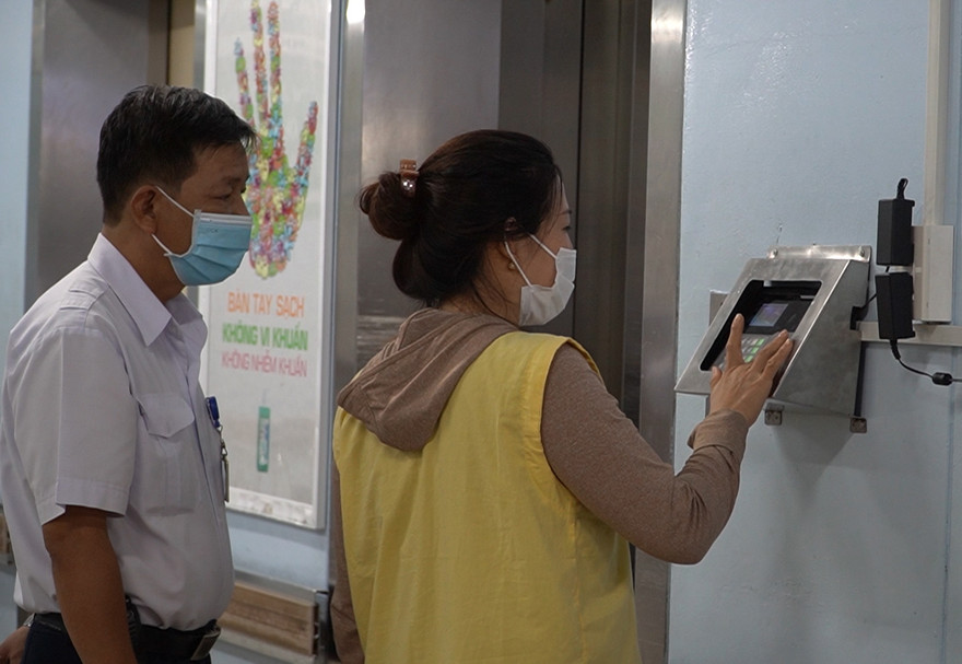 Người nuôi bệnh quét vân tay để vào khu nội trú.