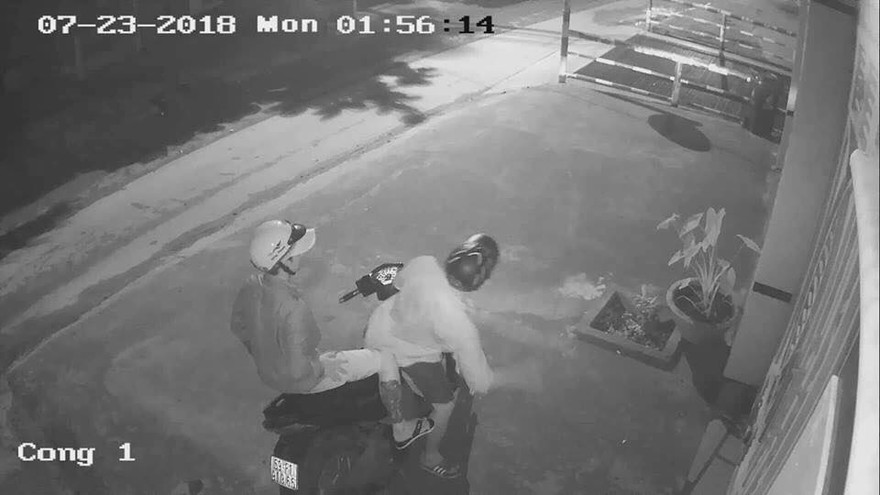 Hai thanh niên đi xe máy đến trước cửa nhà nạn nhân.