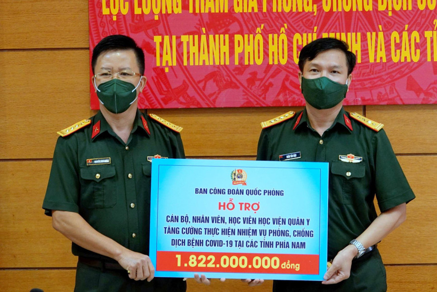 Đại tá Nguyễn Đình Đức, Trưởng ban Công đoàn Quốc phòng (bên trái) trao tặng hỗ trợ cho đại diện Học viện Quân y, sáng 22/9. Ảnh: Nguyễn Minh 