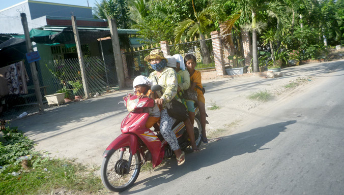 Sau khi phát hiện bị ghi hình, người phụ nữ này nhành chóng điều khiển xe mô tô đến đón nhóm nhí rời khỏi hiện trường. Ảnh: Châu Thành