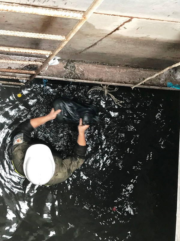 Công nhân vớt lượng lớn rác từ dưới cống lên.