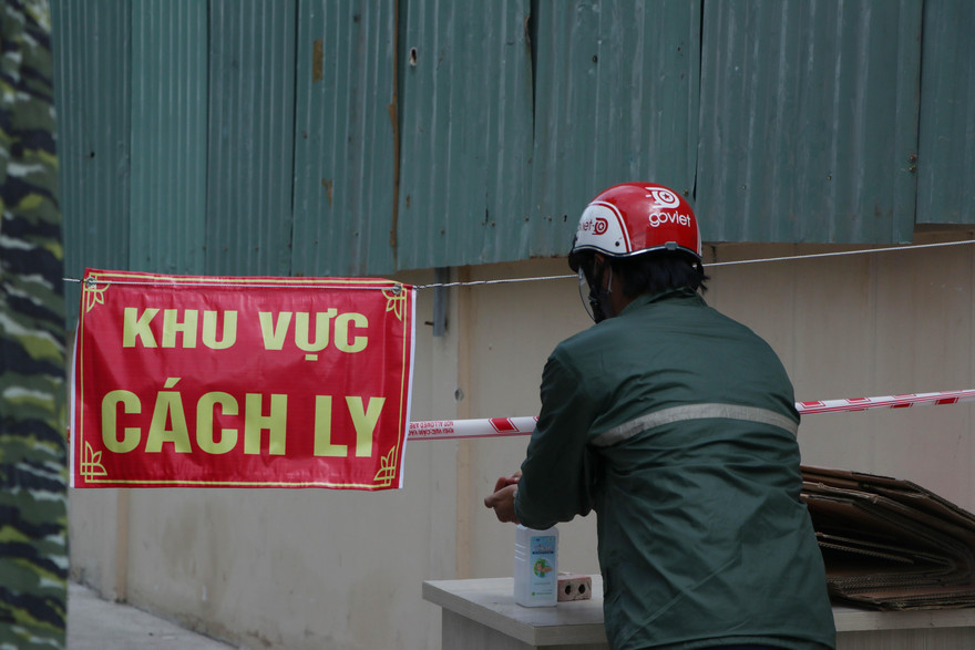 Nhân viên giao hàng được yêu cầu để đồ trên bàn và sát khuẩn tay.