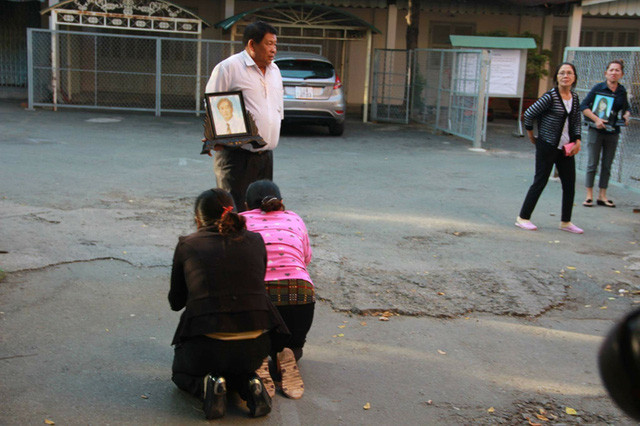 Mẹ bị cáo Vũ Văn Tiến (áo hồng) quỳ lạy trước di ảnh các nạn nhân, cầu xin sự tha thứ cho tội lỗi của con trai.