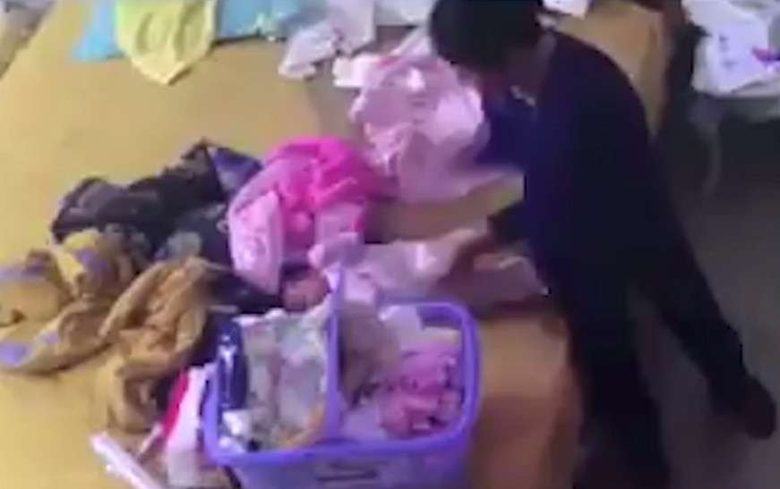 Hình ảnh người giúp việc đánh bé 1 tháng 17 ngày tuổi. Ảnh: Cắt từ clip.