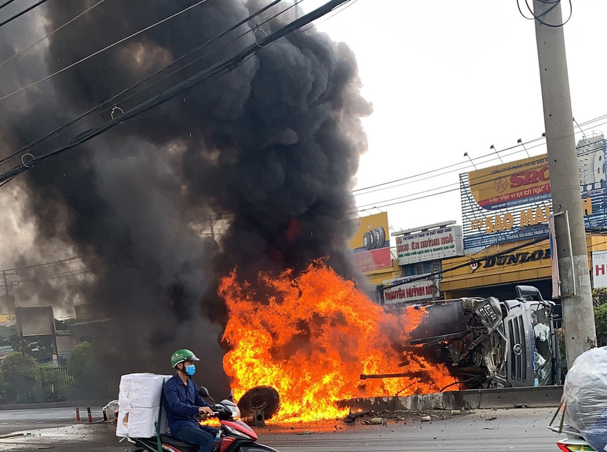 Chiếc xe bốc cháy ngùn ngụt sau khi lật xuống đường.