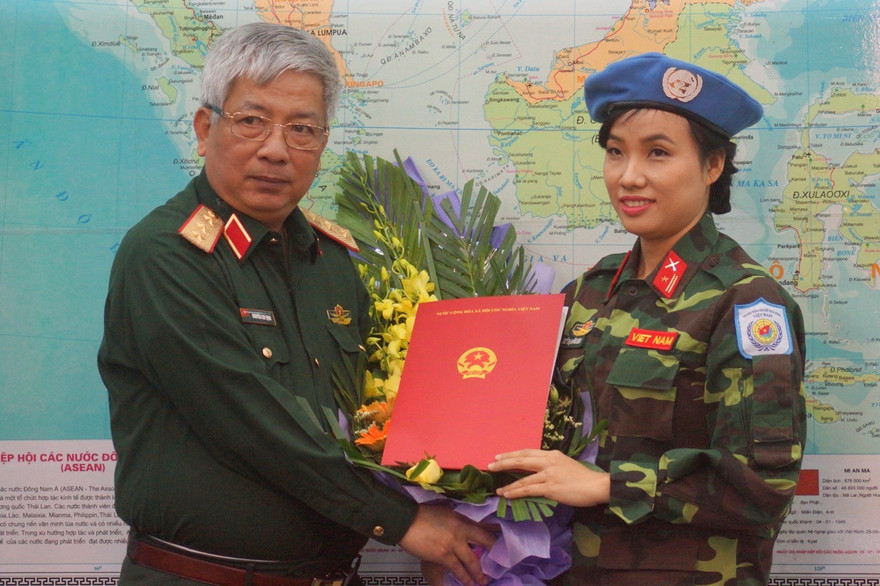 Thượng tướng Nguyễn Chí Vịnh trao quyết định của Chủ tịch nước cho thiếu tá Đỗ Thị Hằng Nga. Ảnh: Nguyễn Minh