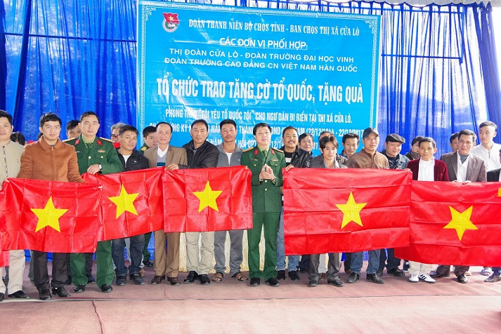 Thượng tá Lê Văn Trung và lãnh đạo Thị ủy Cửa Lò trao cờ Tổ quốc mới cho đại diện các chủ tàu thuyền trên địa bàn thị xã, sáng 17/12