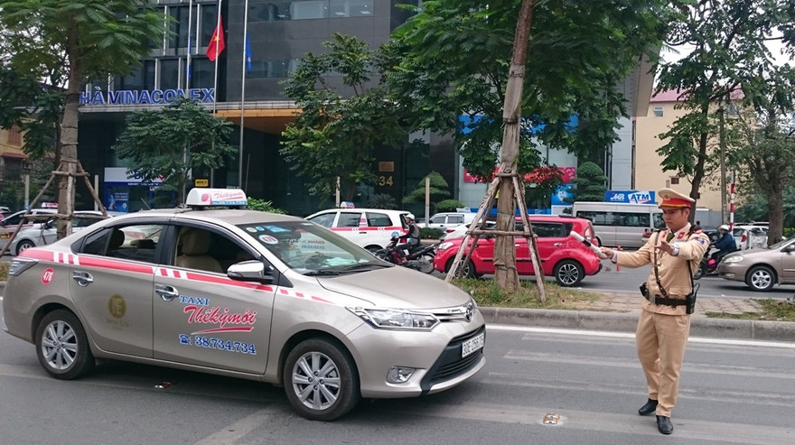 Cảnh sát dừng xe, xử phạt tài xế lần làn buýt nhanh.