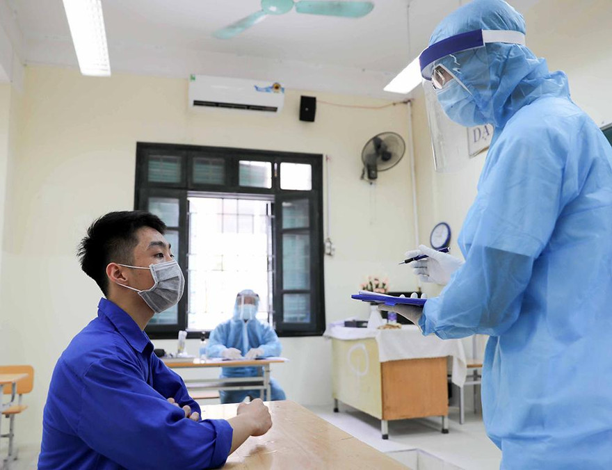 12 tình huống thí sinh nghi mắc COVID-19, nhân viên y tế hướng dẫn thí sinh mặc đồ bảo hộ