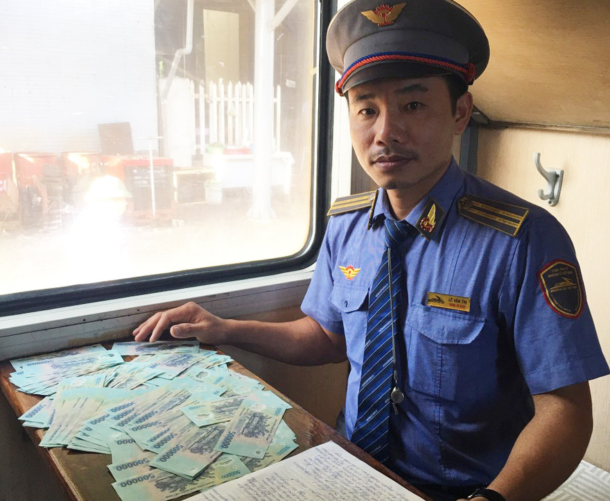 Trưởng tàu SE22 làm thủ tục trả số tiền cho khách để quên