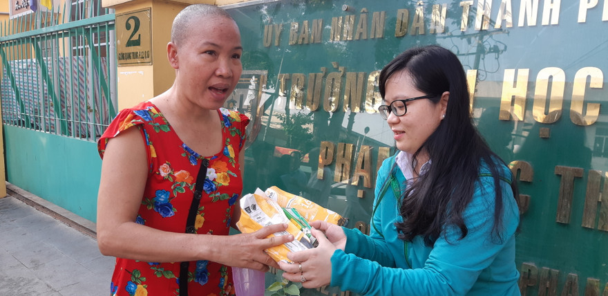 Một bệnh nhân vui mừng nhận bánh mì và sữa từ chương trình