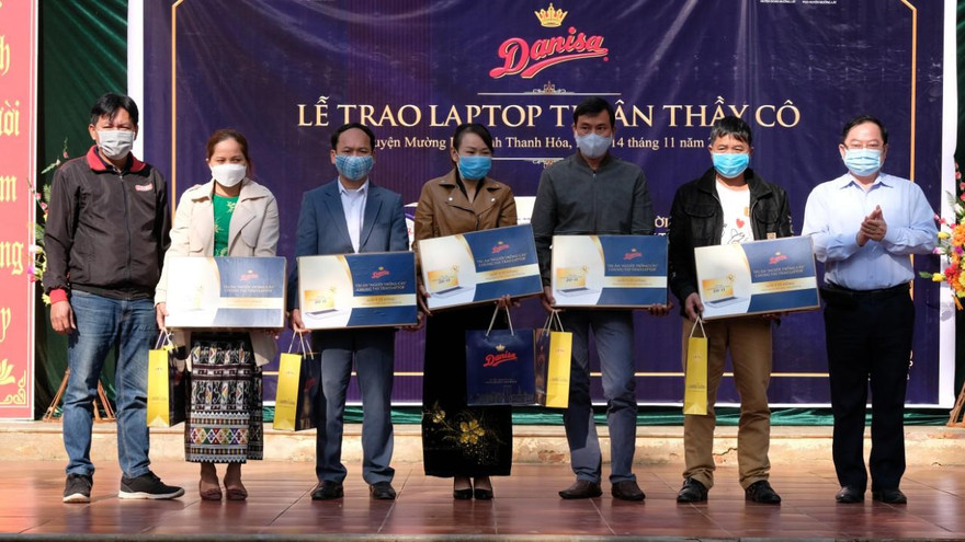 Nhà báo Lê Xuân Sơn (ngoài cùng bên phải) và ông Vũ Tuấn Ngọc – Giám đốc bán hàng khu vực của Danisa (ngoài cùng bên trái) trao tặng laptop và bánh tri ân đến các giáo viên