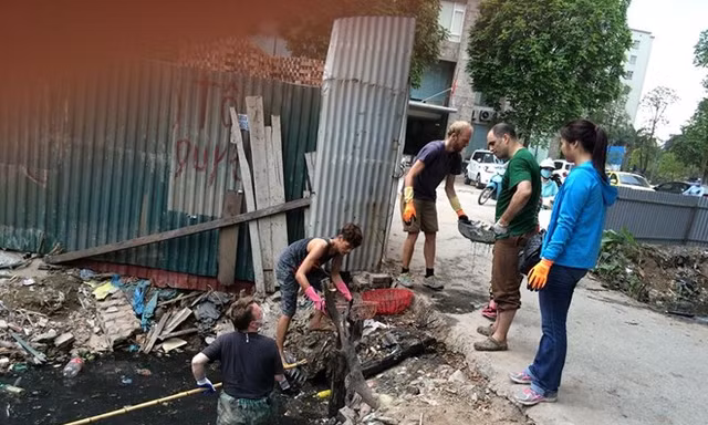 Ba chàng tây tích cực dọn cống bẩn tại phố Nguyễn Khang, Hà Nội. Ảnh: Facebook Mẹ tí