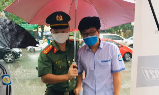 Hình ảnh đẹp chiến sĩ công an dầm mưa che chắn cho sĩ tử 