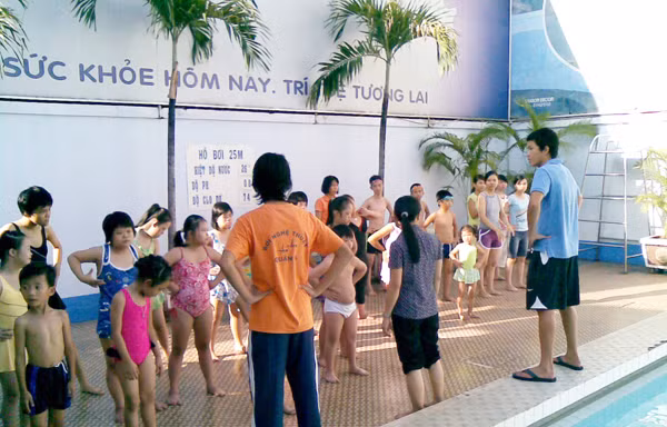 Mỹ Phước (ngòai trái) đang hướng dẫn trẻ khuyết tật trước khi xuống nước