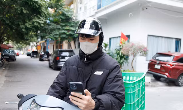 Anh Tiến đang đi giao hàng cho khách. Ảnh: Nguyễn Thắng