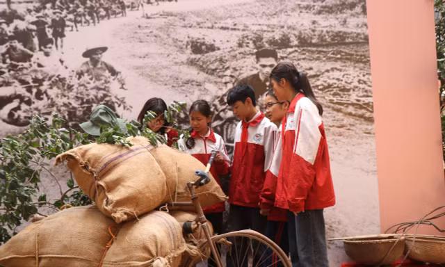 Các em học sinh xem hiện vật Chiến thắng Điện Biên Phủ tại buổi trưng bày.