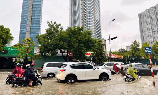 Hà Nội mưa lớn không ngớt, người dân lội nước đi làm
