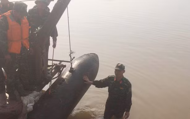 Quả bom dưới chân cầu Long Biên được lai dắt vào bờ chiều qua, 28/11. 