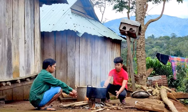 Học sinh lớp 9 Đinh Hợi (phải) và bố nấu ăn ngoài trời 