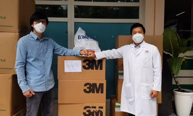Đại diện Báo Tiền Phong tại TPHCM (trái) tặng đồ bảo hộ khẩu trang cho Bệnh viện Nhân Dân 115