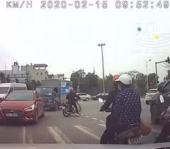 Mặc kệ dòng người qua lại, cô gái thản nhiên dừng xe máy giữa đường