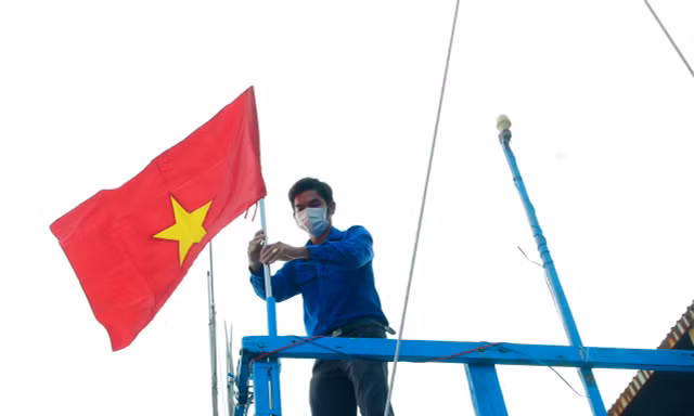 Thanh niên Khánh Hoà gắn cờ Tổ quốc lên tàu cá ngư dân