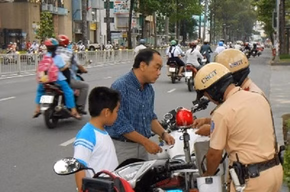 Kể từ ngày 10/4 đồng loạt xử phạt trường hợp không đội mũ bảo hiểm cho trẻ trên 6 tuổi khi ngồi trên xe mô tô, gắn máy...lưu thông trên đường.