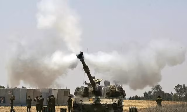 Một chiếc xe tăng của quân đội Israel bắn về phía Dải Gaza. Ảnh: AP